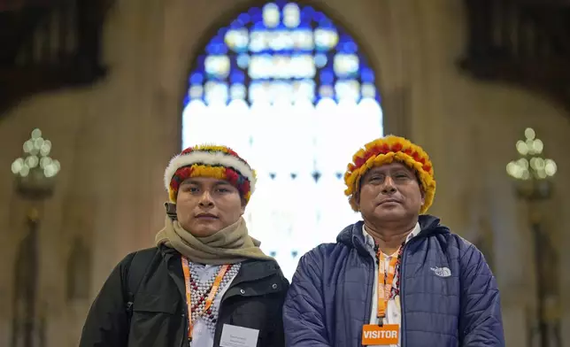 Indigenous leaders from the Wampis Nation in Peru, Tsanim Evaristo Wajai Asamat, left, and Pamuk Teofilo Kukush Pati, pose inside the Westminster Hall in London, Thursday, Nov. 21, 2024. (AP Photo/Kin Cheung)