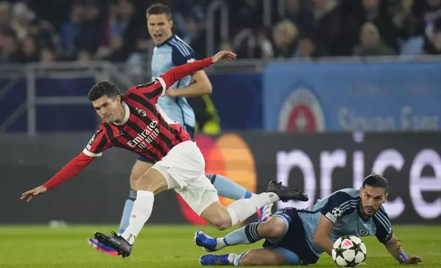 AC Milan's Christian Pulisic, left, Slovan's Kyriakos Savvidis fight for the ball during the Champions League opening phase soccer match between Slovan Bratislava and AC Milan in Bratislava, Slovakia, on Tuesday, Nov. 26, 2024. (AP Photo/Petr David Josek)