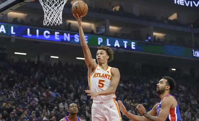 Atlanta Hawks guard Dyson Daniels (5) lays the ball up over Sacramento Kings forward Trey Lyles, right, during the first half of an NBA basketball game in Sacramento, Calif., Monday, Nov. 18, 2024. (AP Photo/Randall Benton)