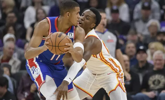 Sacramento Kings center Orlando Robinson, left, is guarded by Atlanta Hawks forward Onyeka Okongwu, right, during the first half of an NBA basketball game in Sacramento, Calif., Monday, Nov. 18, 2024. (AP Photo/Randall Benton)