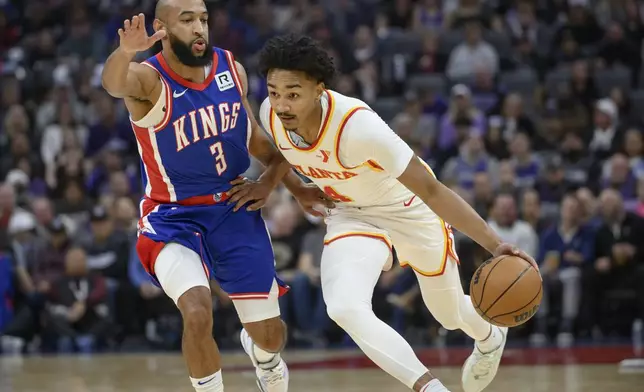 Atlanta Hawks guard Kobe Bufkin, right, is guarded by Sacramento Kings guard Jordan McLaughlin (3) during the first half of an NBA basketball game in Sacramento, Calif., Monday, Nov. 18, 2024. (AP Photo/Randall Benton)