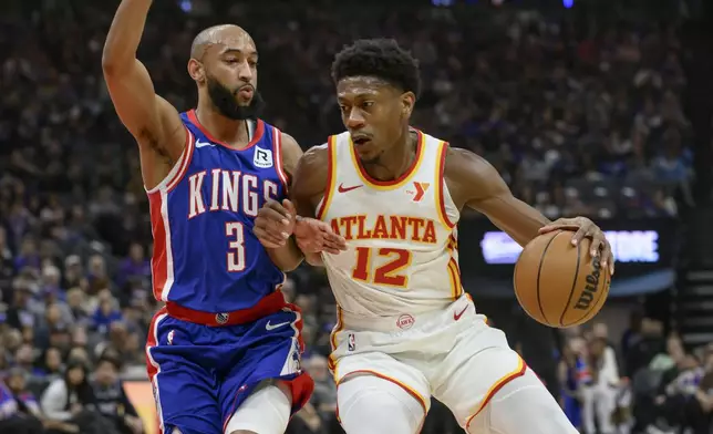 Atlanta Hawks forward De'Andre Hunter (12) is guarded by Sacramento Kings guard Jordan McLaughlin (3) during the first half of an NBA basketball game in Sacramento, Calif., Monday, Nov. 18, 2024. (AP Photo/Randall Benton)