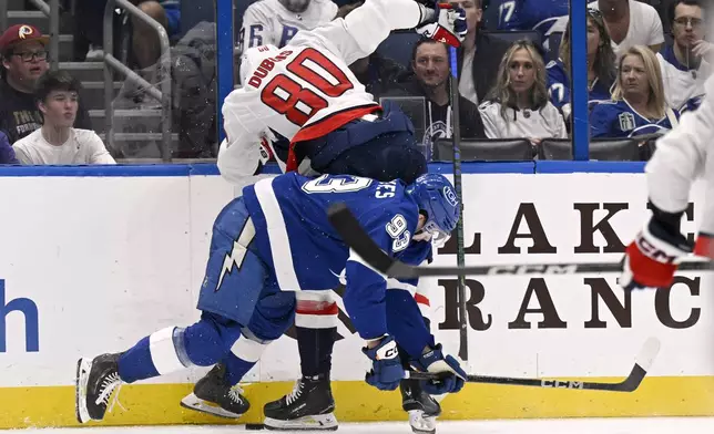 Washington Capitals left wing Pierre-Luc Dubois (80) and Tampa Bay Lightning center Gage Goncalves (93) battle along the boards during the second period of an NHL hockey game, Wednesday, Nov. 27, 2024, in Tampa, Fla. (AP Photo/Jason Behnken)