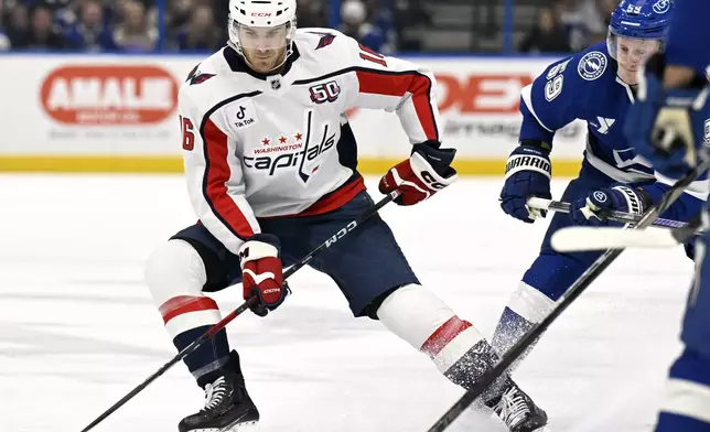 Washington Capitals right wing Taylor Raddysh (16) handles the puck against Tampa Bay Lightning center Jake Guentzel (59) during the first period of an NHL hockey game Wednesday, Nov. 27, 2024, in Tampa, Fla. (AP Photo/Jason Behnken)