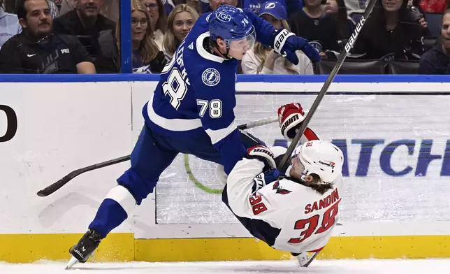 Tampa Bay Lightning defenseman Emil Lilleberg (78) checks Washington Capitals defenseman Rasmus Sandin (38) during the first period of an NHL hockey game Wednesday, Nov. 27, 2024, in Tampa, Fla. (AP Photo/Jason Behnken)