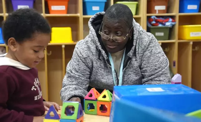 Volunteer Mirna Cruz Mangual, 59, of Providence, R.I., right, supervises three-year-old Yovanni Freeman, left, in an early childcare program at Federal Hill House, Tuesday, Nov. 12, 2024, in Providence, R.I. (AP Photo/Steven Senne)