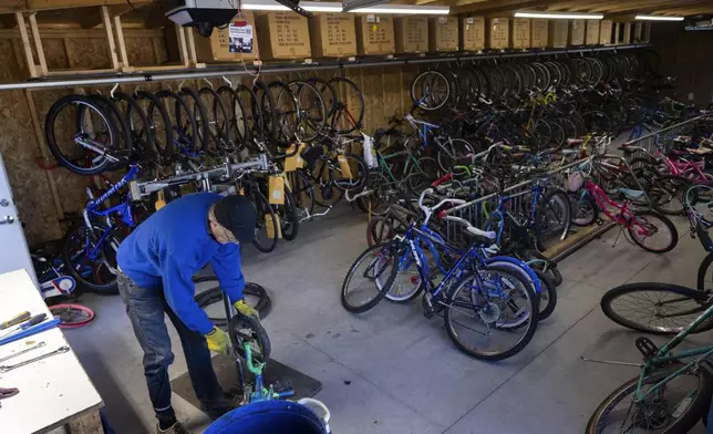 Volunteer Gerry Friberg scraps a bike for parts in the donation annex of the Lincoln Bike Kitchen on Tuesday, Nov. 12, 2024, in Lincoln, Neb. (AP Photo/Rebecca S. Gratz)