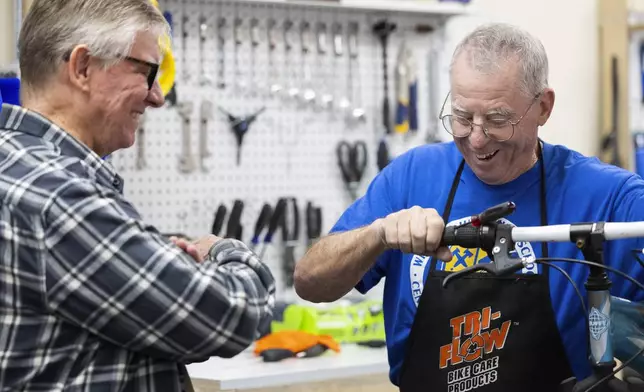 Volunteer Wayne Schafer, right, works on a bicycle while teaching new volunteer apprentice mechanic Paul Eisloeffel at Lincoln Bike Kitchen on Tuesday, Nov. 12, 2024, in Lincoln, Neb. (AP Photo/Rebecca S. Gratz)