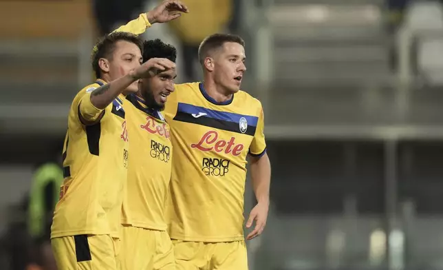 Atalanta's Ederson, center, celebrates with Mateo Retegui, left, and Mario Pasalic after scoring during the Italian Serie A soccer match between Parma and Atalanta at the Ennio Tardini Stadium in Parma, Italy, Saturday Nov. 23, 2024. (Massimo Paolone/LaPresse via AP)