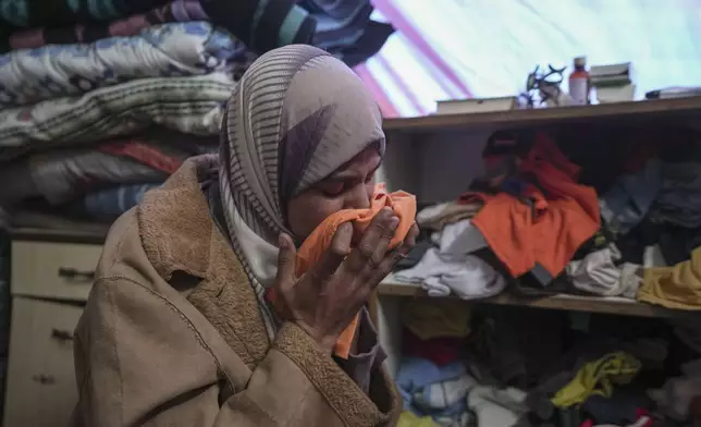 Areej al Qadi weeps of one of her children's clothes after the funeral of her three children in Khan Younis, Gaza Strip, Thursday Nov. 21, 2024. Seven-year-old Hamza, his five-year-old brother Abdelaziz, and his four-year-old sister Laila Hassan were among 9 people killed by an Israeli strike in Khan Younis on Wednesday. Palestinian health officials say the death toll in the Gaza Strip from the 13-month-old war between Israel and Hamas has surpassed 44,000. (AP Photo/Abdel Kareem Hana)