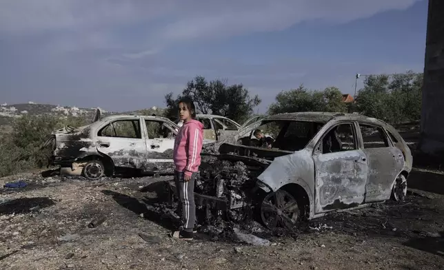 A Palestinian girl looks at a damaged cars following an Israeli airstrike in the West Bank city of Jenin, Thursday, Nov. 21, 2024. (AP Photo/Majdi Mohammed)