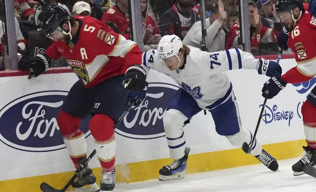 Florida Panthers defenseman Aaron Ekblad (5) and Toronto Maple Leafs center Bobby McMann (74) go for the puck during the first period of an NHL hockey game, Wednesday, Nov. 27, 2024, in Sunrise, Fla. (AP Photo/Lynne Sladky)