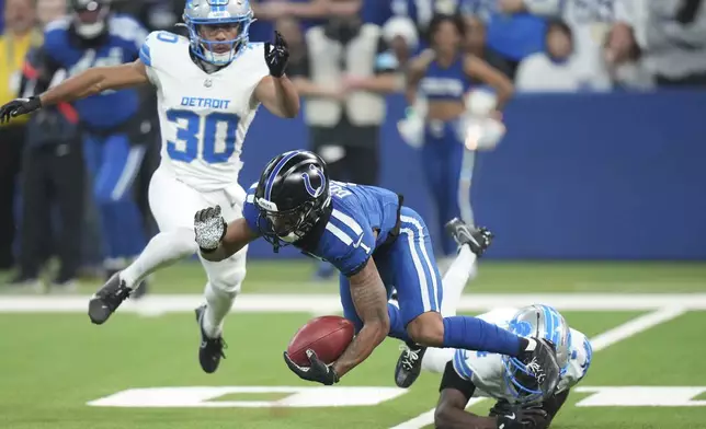 Detroit Lions cornerback Emmanuel Moseley (4) trips Indianapolis Colts wide receiver Josh Downs (1) during the first half of an NFL football game, Sunday, Nov. 24, 2024, in Indianapolis. (AP Photo/AJ Mast)