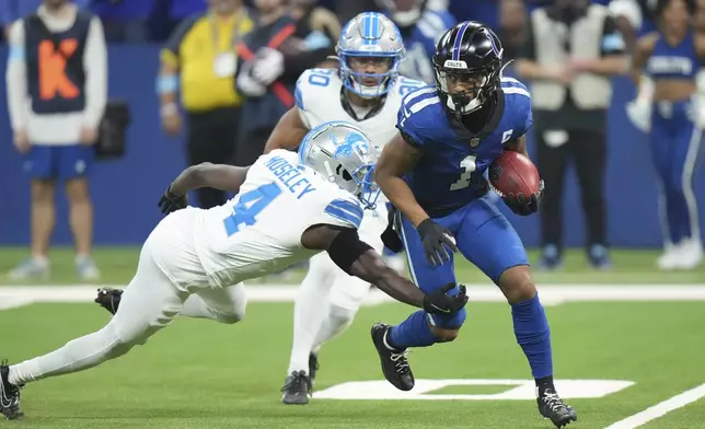 Detroit Lions cornerback Emmanuel Moseley (4) reaches in on Indianapolis Colts wide receiver Josh Downs (1) during the first half of an NFL football game, Sunday, Nov. 24, 2024, in Indianapolis. (AP Photo/AJ Mast)