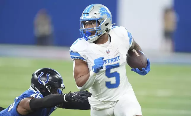 Detroit Lions running back David Montgomery (5) pulls away from Indianapolis Colts linebacker E.J. Speed (45) during the first half of an NFL football game, Sunday, Nov. 24, 2024, in Indianapolis. (AP Photo/Michael Conroy)