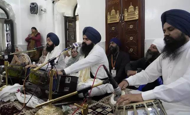 A group of Sikh pilgrims sing religious songs as they attend their first Sikh guru, Guru Nanak Dev, birth anniversary celebrations at his shrine at the Gurdwara Darbar Sahib, in Kartarpur, Pakistan, Tuesday, Nov. 19, 2024. (AP Photo/Anjum Naveed)