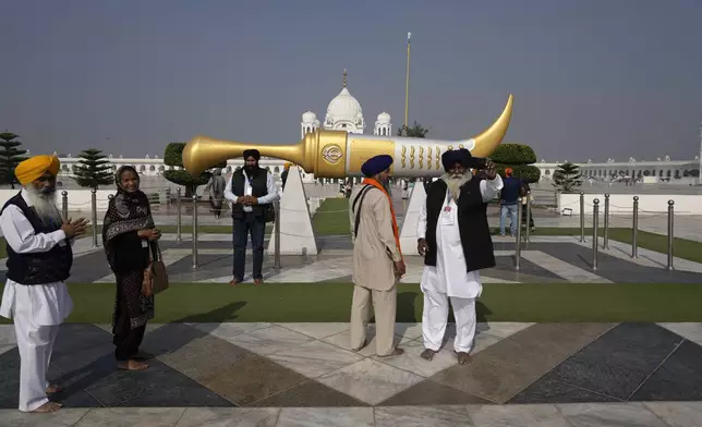 Sikh pilgrims pose for selfie as they attend their first Sikh guru, Guru Nanak Dev, birth anniversary celebrations at his shrine at the Gurdwara Darbar Sahib, in Kartarpur, Pakistan, Tuesday, Nov. 19, 2024. (AP Photo/Anjum Naveed)