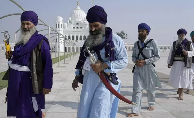 Sikh pilgrims arrive to attend their first Sikh guru, Guru Nanak Dev, birth anniversary celebrations at his shrine at the Gurdwara Darbar Sahib, in Kartarpur, Pakistan, Tuesday, Nov. 19, 2024. (AP Photo/Anjum Naveed)