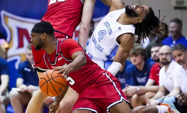 Dayton guard Posh Alexander, left, fouls North Carolina guard RJ Davis (4) as Dayton forward Amael L'Etang (29) guards during the second half of an NCAA college basketball game at the Maui Invitational Monday, Nov. 25, 2024, in Lahaina, Hawaii. (AP Photo/Lindsey Wasson)