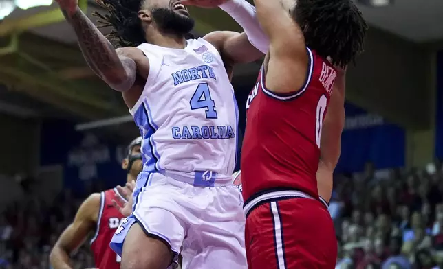 North Carolina guard RJ Davis (4) goes to the basket against Dayton guard Javon Bennett (0) during the second half of an NCAA college basketball game at the Maui Invitational Monday, Nov. 25, 2024, in Lahaina, Hawaii. (AP Photo/Lindsey Wasson)