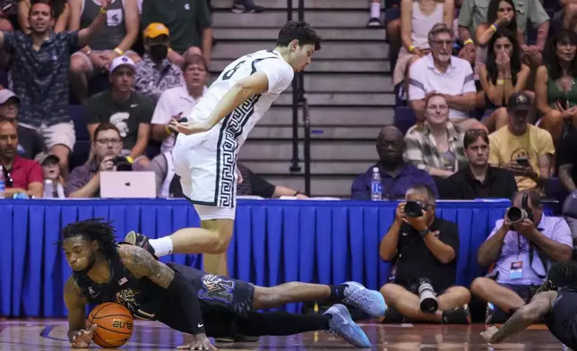 Memphis guard Tyrese Hunter falls while trying to recover the ball against Michigan State forward Frankie Fidler during the first half of an NCAA college basketball game at the Maui Invitational Tuesday, Nov. 26, 2024, in Lahaina, Hawaii. (AP Photo/Lindsey Wasson)