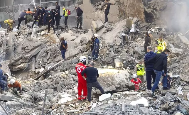 Rescue workers and people search for victims at the site of an Israeli airstrike that hit central Beirut, Lebanon, Saturday, Nov. 23, 2024. (AP Photo/Hassan Ammar)