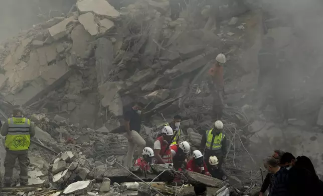 Rescue workers and people search for victims at the site of an Israeli airstrike that hit central Beirut, Lebanon, Saturday, Nov. 23, 2024. (AP Photo/Hassan Ammar)