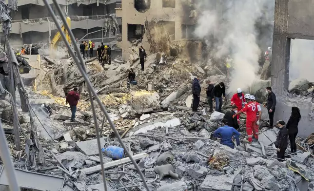 Rescue workers and people search for victims at the site of an Israeli airstrike that hit central Beirut, Lebanon, Saturday, Nov. 23, 2024. (AP Photo/Hassan Ammar)