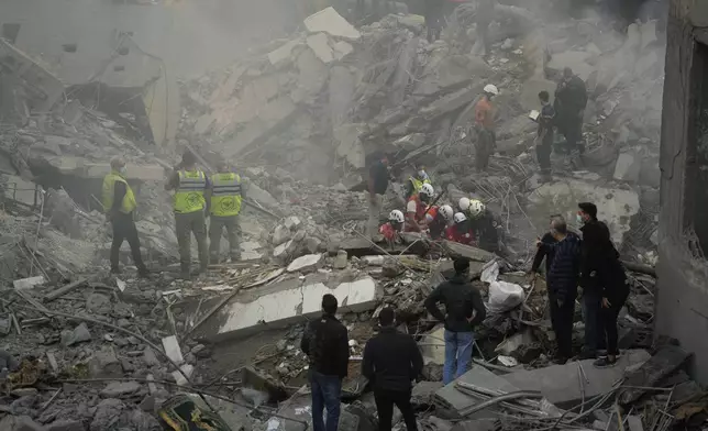 Rescue workers and people search for victims at the site of an Israeli airstrike that hit central Beirut, Lebanon, Saturday, Nov. 23, 2024. (AP Photo/Hassan Ammar)