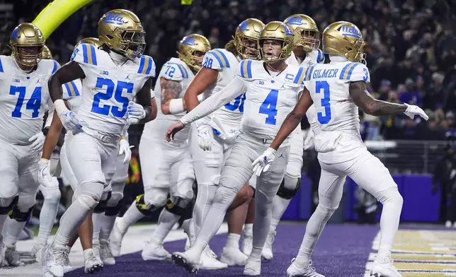 UCLA quarterback Ethan Garbers (4) reacts after throwing a touchdown to wide receiver Kwazi Gilmer (3) against Washington during the first half of an NCAA college football game Friday, Nov. 15, 2024, in Seattle. (AP Photo/Lindsey Wasson)