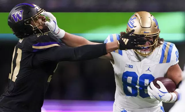 UCLA tight end Moliki Matavao (88) stiff-arms Washington edge Isaiah Ward during the first half of an NCAA college football game Friday, Nov. 15, 2024, in Seattle. (AP Photo/Lindsey Wasson)