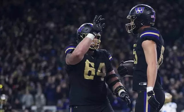 Washington offensive lineman Gaard Memmelaar (64) celebrates with tight end Keleki Latu after Latu's touchdown against UCLA during the first half of an NCAA college football game Friday, Nov. 15, 2024, in Seattle. (AP Photo/Lindsey Wasson)