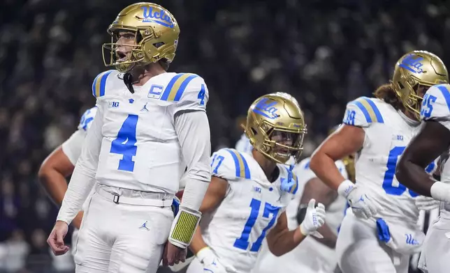 UCLA quarterback Ethan Garbers (4) reacts to throwing a touchdown pass to wide receiver Kwazi Gilmer during the first half of an NCAA college football game against Washington, Friday, Nov. 15, 2024, in Seattle. (AP Photo/Lindsey Wasson)