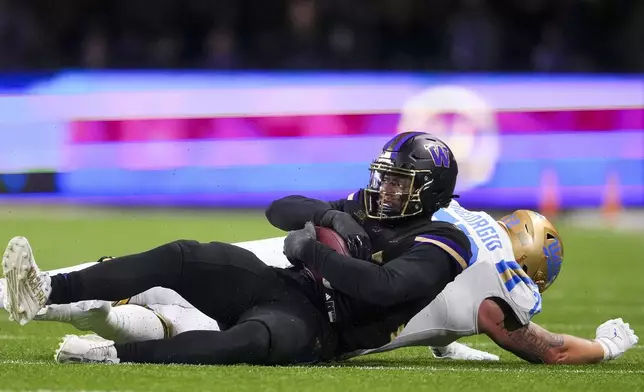 Washington defensive lineman Russell Davis II recovers a fumble against UCLA offensive lineman Garrett DiGiorgio during the first half of an NCAA college football game Friday, Nov. 15, 2024, in Seattle. (AP Photo/Lindsey Wasson)