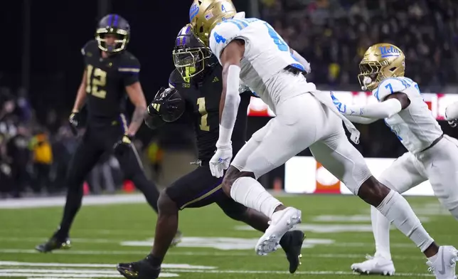 Washington running back Jonah Coleman (1) runs the ball on his way to a touchdown against UCLA defensive back Bryan Addison (4) during the first half of an NCAA college football game Friday, Nov. 15, 2024, in Seattle. (AP Photo/Lindsey Wasson)