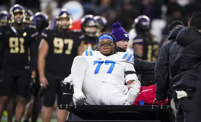 UCLA offensive lineman Jaylan Jeffers is carted off the field with an injury during the first half of an NCAA college football game against Washington, Friday, Nov. 15, 2024, in Seattle. (AP Photo/Lindsey Wasson)