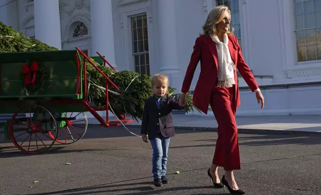 First lady Jill Biden, right, walks with her grandson Beau Biden after receiving the official 2024 White House Christmas Tree on the North Portico of the White House in Washington, Monday, Nov. 25, 2024. Cartner's Christmas Tree Farm from Newland, N.C., provided the Fraser fir that will be displayed in the Blue Room of the White House. (AP Photo/Susan Walsh)