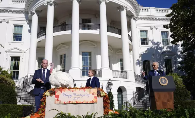 President Joe Biden speaks and pardons the national Thanksgiving turkey, Peach, during a pardoning ceremony on the South Lawn of the White House in Washington, Monday, Nov. 25, 2024, as John Zimmerman, chair of the National Turkey Federation and his son Grant, look on. (AP Photo/Susan Walsh)