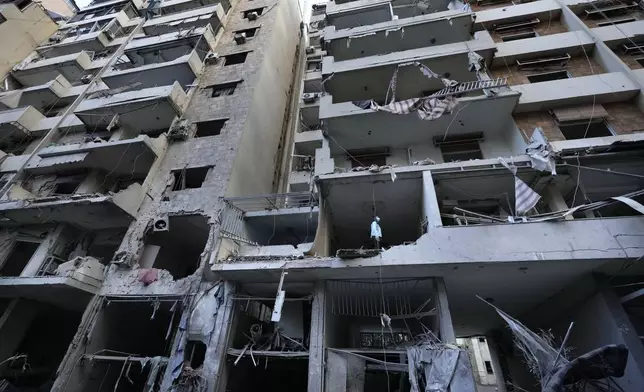 A woman looks through her damaged apartment which was resulted from Sunday's Israeli airstrike in Dahiyeh, in the southern suburb of Beirut, Lebanon, Monday, Nov. 25, 2024. (AP Photo/Hussein Malla)