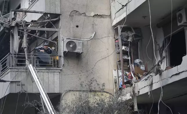 A man throws debris from his damaged apartment which was resulted from Sunday's Israeli airstrike in Dahiyeh, in the southern suburb of Beirut, Lebanon, Monday, Nov. 25, 2024. (AP Photo/Hussein Malla)