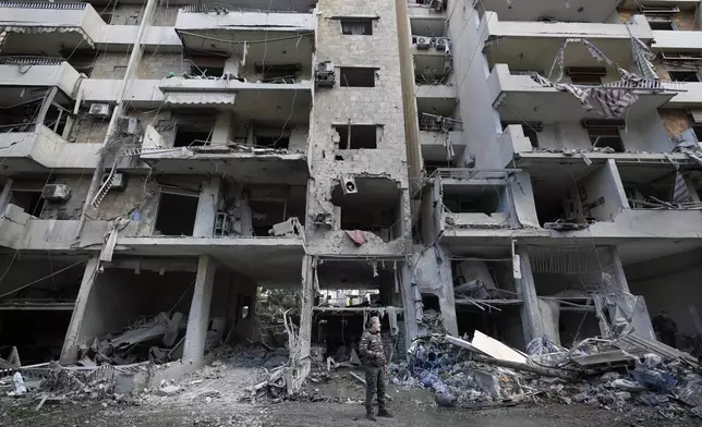 A man stands in front of a destroyed building after Sunday's Israeli airstrike in Dahiyeh, in the southern suburb of Beirut, Lebanon, Monday, Nov. 25, 2024. (AP Photo/Hussein Malla)