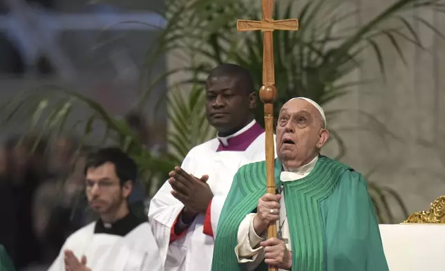 Pope Francis looks at the cross as he presides over a mass on the occasion of the World Day of the Poor in St. Peter's Basilica, at the Vatican, Sunday, Nov. 17, 2024. (AP Photo/Alessandra Tarantino)