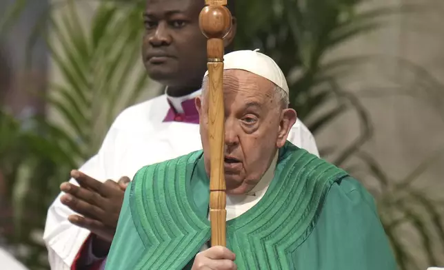 Pope Francis holds the cross as he presides over a mass on the occasion of the World Day of the Poor in St. Peter's Basilica, at the Vatican, Sunday, Nov. 17, 2024. (AP Photo/Alessandra Tarantino)