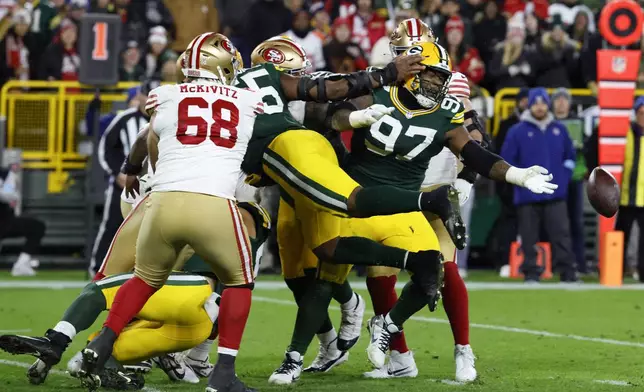 Green Bay Packers defensive tackle Kenny Clark (97) recovers a fumble during the second half of an NFL football game against the San Francisco 49ers on Sunday, Nov. 24, 2024 in Green Bay, Wis. (AP Photo/Mike Roemer)