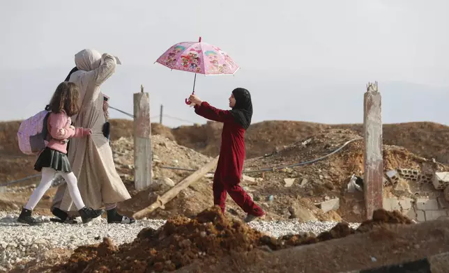 A family arrive to cross into Lebanon through the Jousieh border crossing, between Syria and Lebanon, Thursday, Nov. 28, 2024, following a ceasefire between Israel and Hezbollah that went into effect on Wednesday. (AP Photo/Omar Sanadiki)