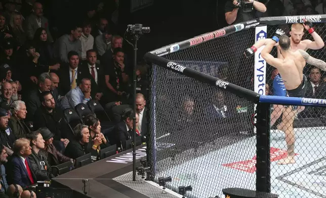 President-elect Donald Trump watches as Bo Nickal, facing camera, fights Scotland's Paul Craig at UFC 309 at Madison Square Garden, Saturday, Nov. 16, 2024, in New York. (AP Photo/Evan Vucci)