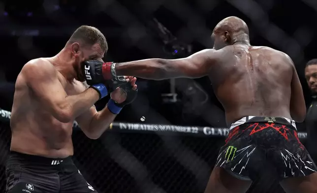 Jon Jones, right, punches Stipe Miocic in a UFC 309 mixed martial arts heavyweight title bout, early on Sunday, Nov. 17, 2024, in New York. (AP Photo/Adam Hunger)