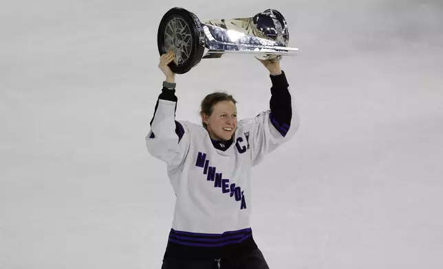 FILE - Minnesota captain Kendall Coyne Schofield celebrates with the trophy after beating Boston in Game 5 of the PWHL Walter Cup hockey finals, May 29, 2024, in Lowell, Mass. (AP Photo/Mary Schwalm, File)