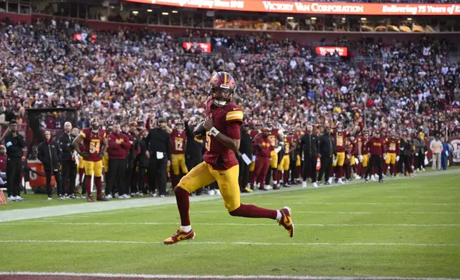 Washington Commanders quarterback Jayden Daniels (5) scores on a 2-point conversion attempt during the second half of an NFL football game against the Dallas Cowboys, Sunday, Nov. 24, 2024, in Landover, Md. (AP Photo/Nick Wass)