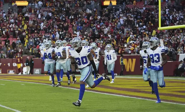 Dallas Cowboys safety Juanyeh Thomas (30) celebrates after scoring a 43-yard touchdown off a kickoff return during the second half of an NFL football game against the Washington Commanders, Sunday, Nov. 24, 2024, in Landover, Md. (AP Photo/Stephanie Scarbrough)